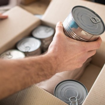 Person putting canned food in a box