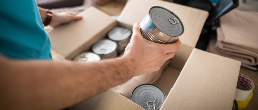 Person putting canned food in a box